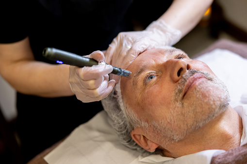 Man At The Spa Getting An Anti Aging Treatment On His Face