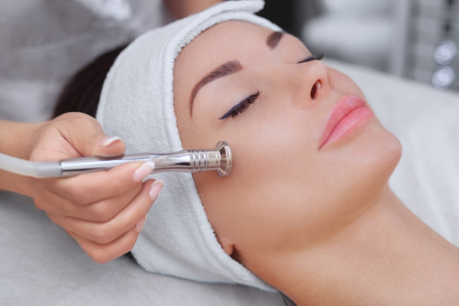 The Cosmetologist Makes The Procedure Microdermabrasion Of The Facial Skin Of A Beautiful, Young Woman